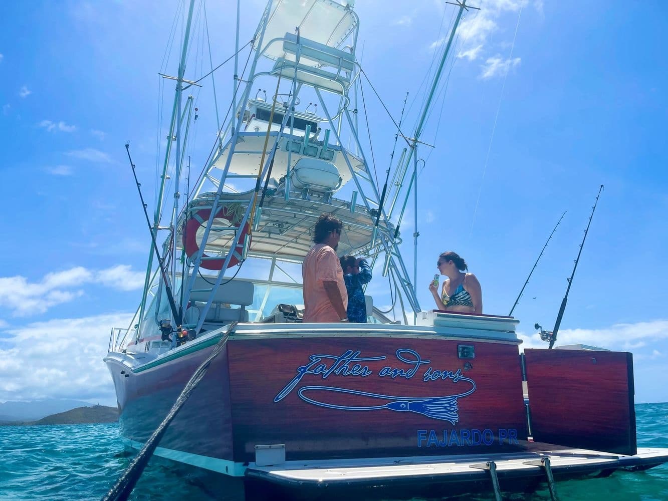 Sportfishing charter boat in turquoise tropical sea, anglers prepping