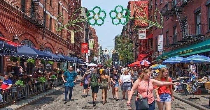 Pedestrians strolling a bustling Manhattan street food market