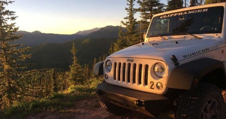 Jeep Rubicon parked at sunset on mountain overlook Colorado