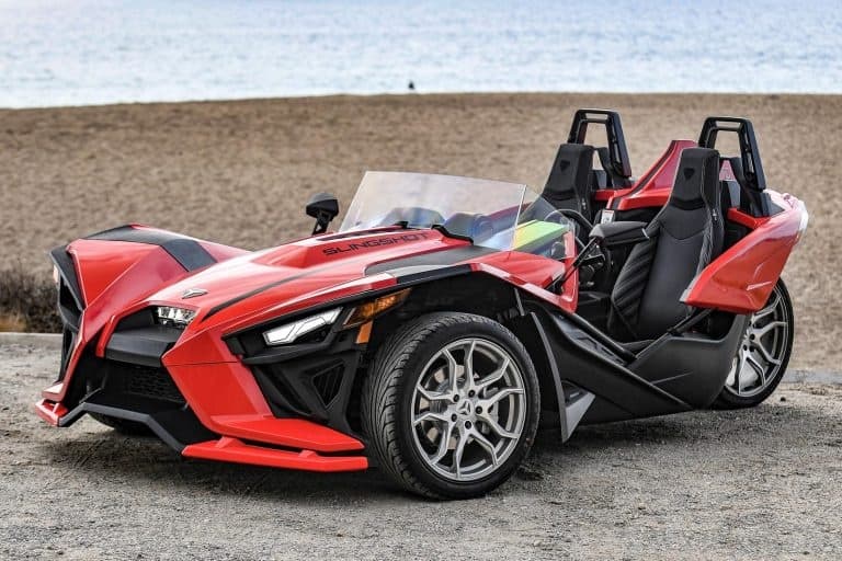 Red Polaris Slingshot on sandy beach ready for coastal ride