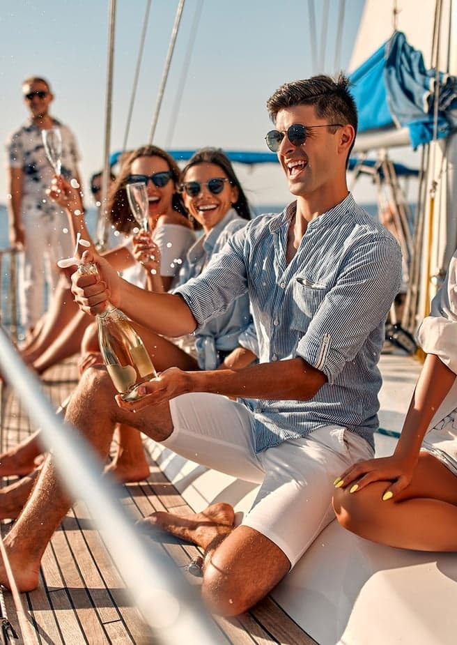 Friends enjoying a sailing cruise on yacht deck in daytime