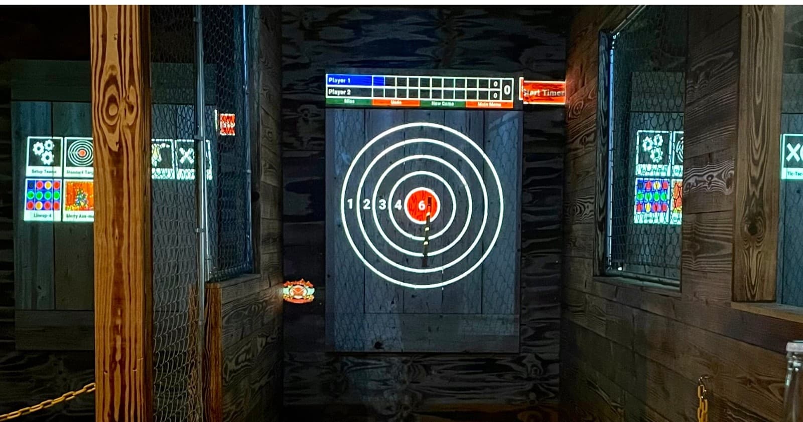 Dimly lit illuminated axe target board inside Ocala throwing range