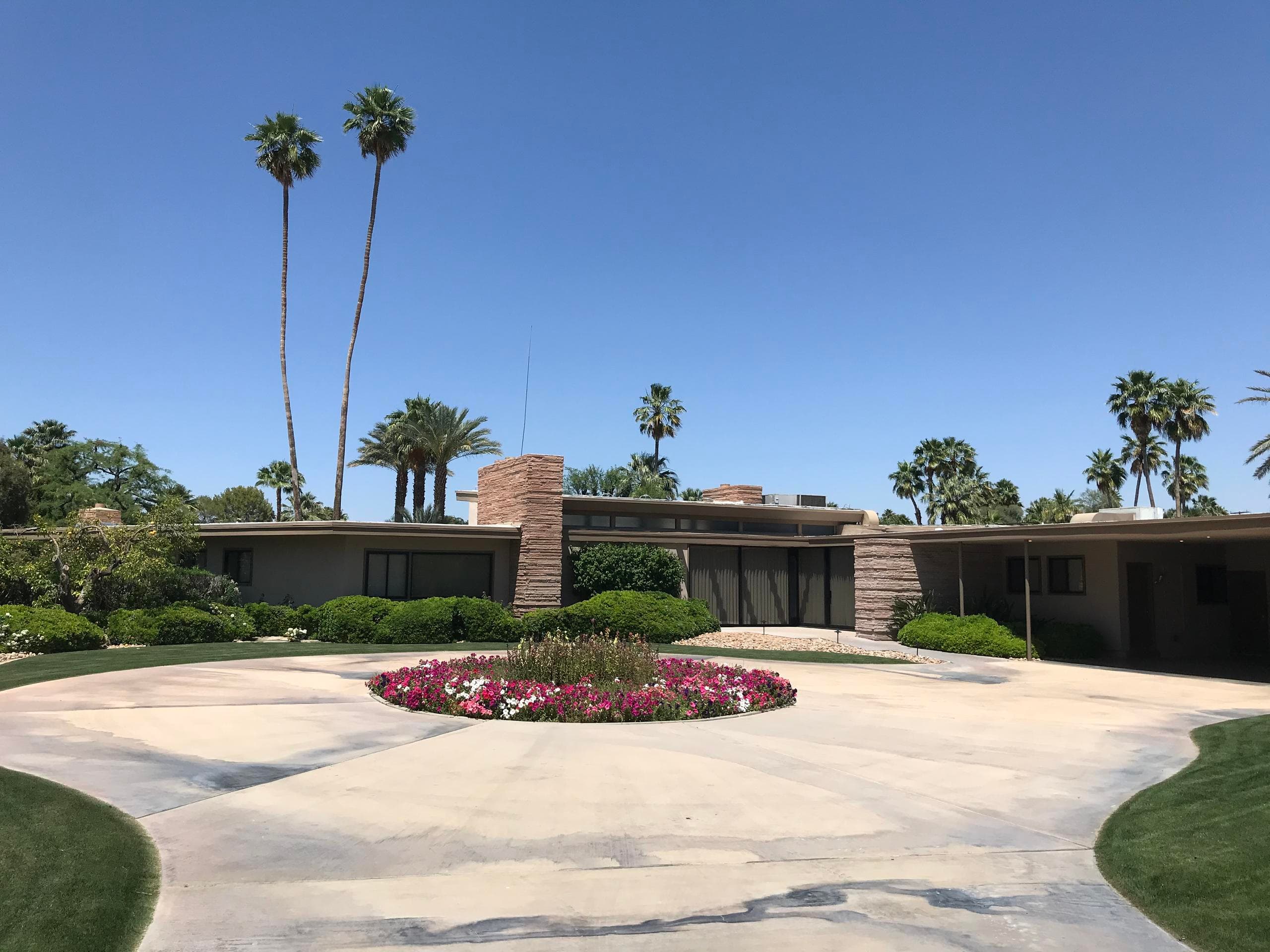 Palm Springs circular driveway and palm-lined entrance view