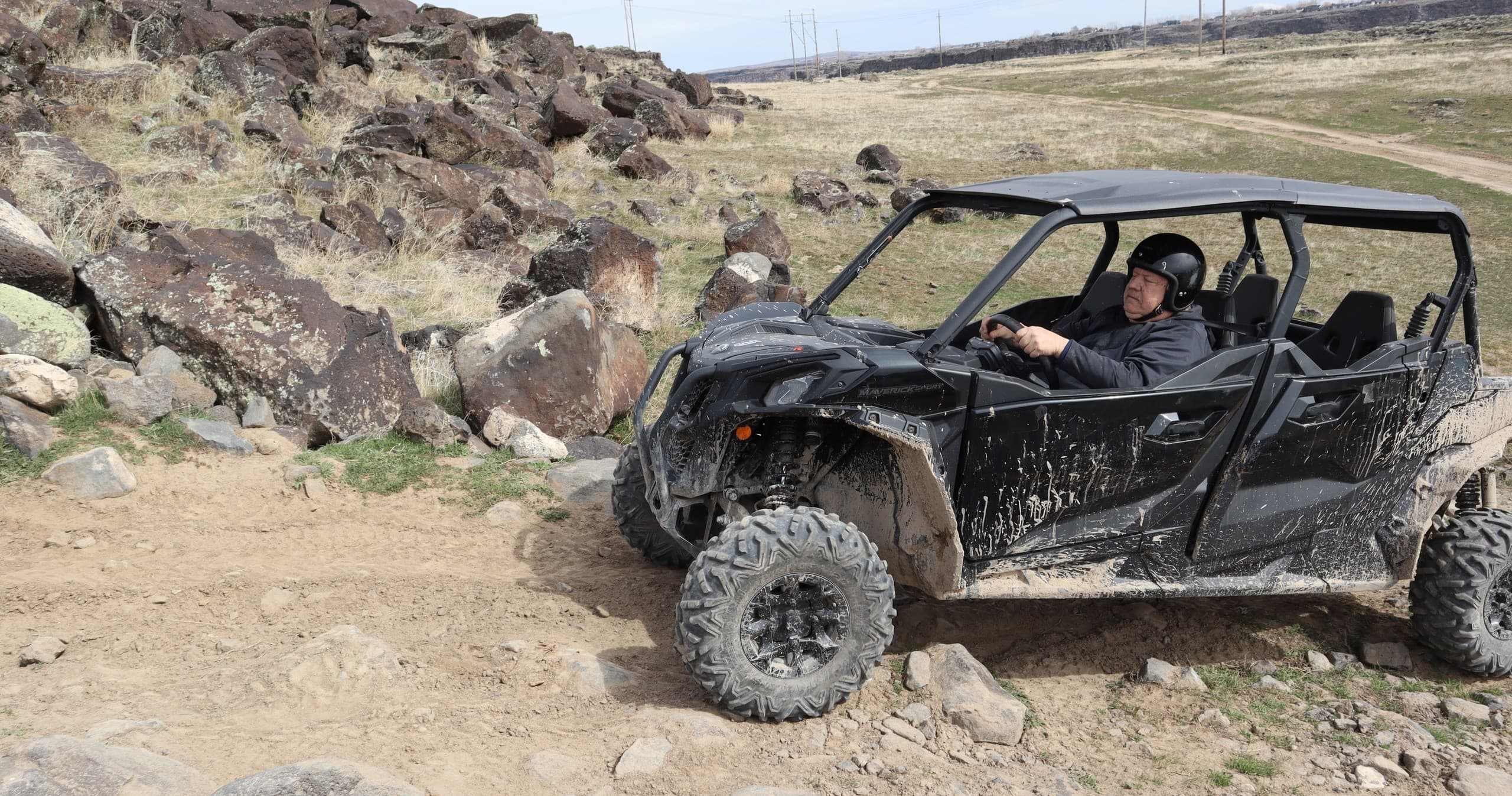 Side-by-side UTV driving over rocky desert trail for off-road adventure