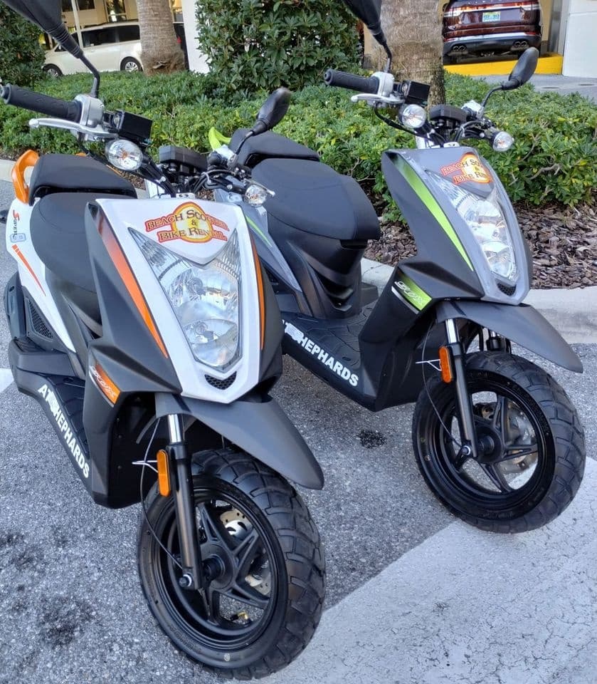 Pair of rental scooters ready for beach cruising on street