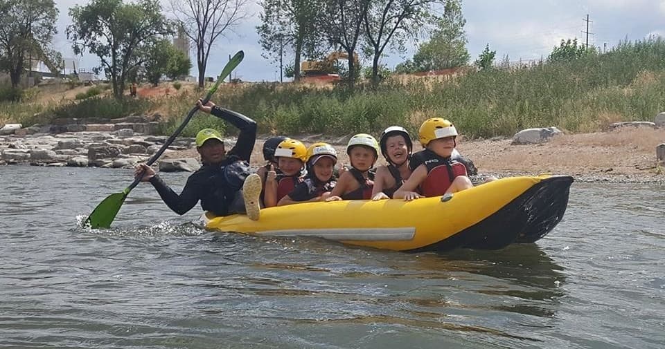 Guided rafting team paddling a yellow inflatable on scenic river