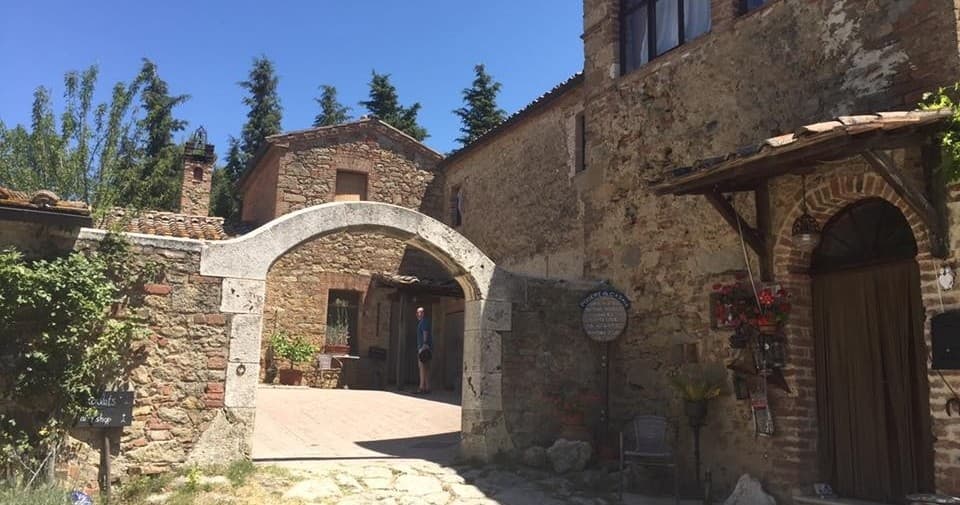 Historic stone archway and village street in Tuscany outdoors