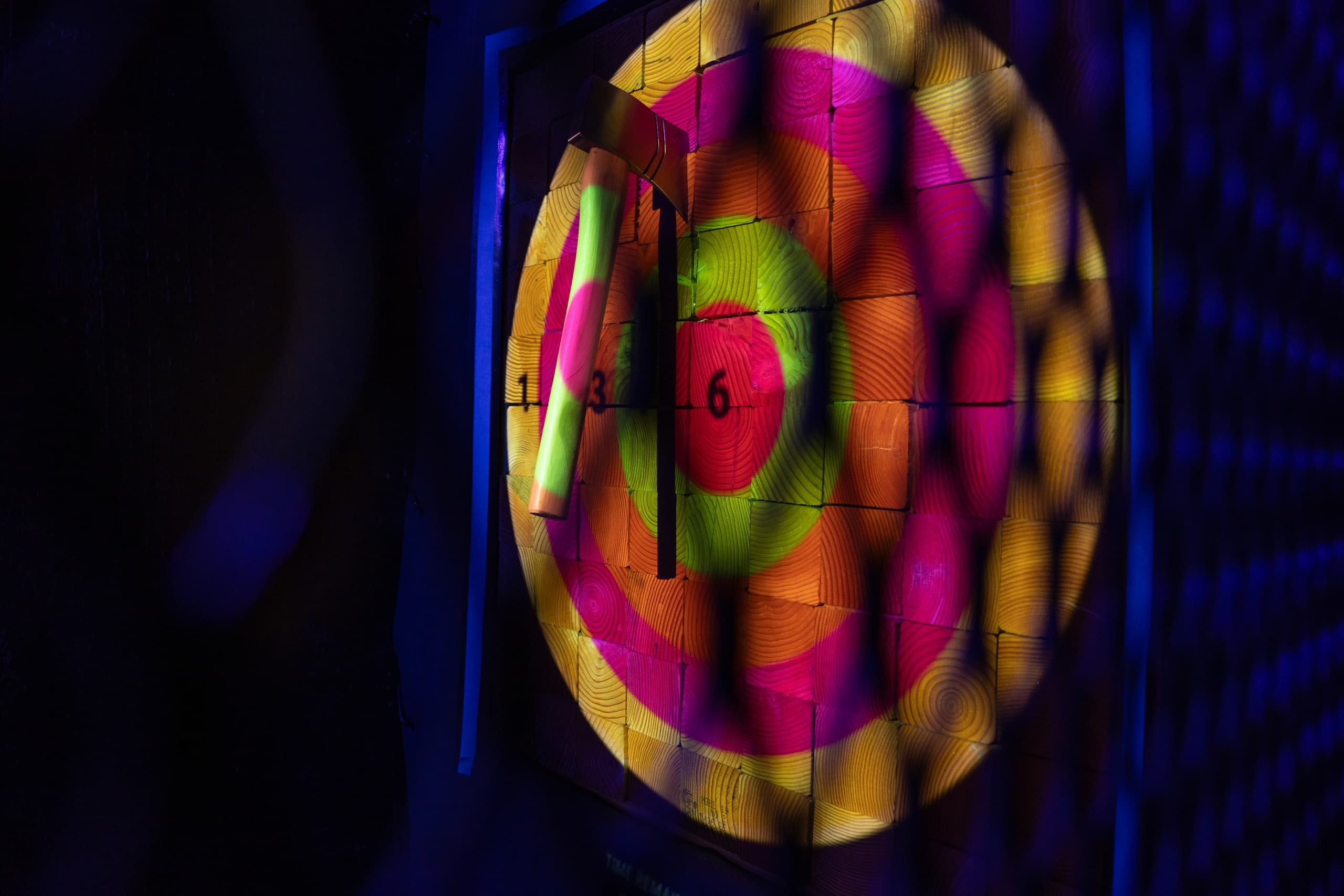 Vibrant bullseye target lit by colored lights at entertainment venue