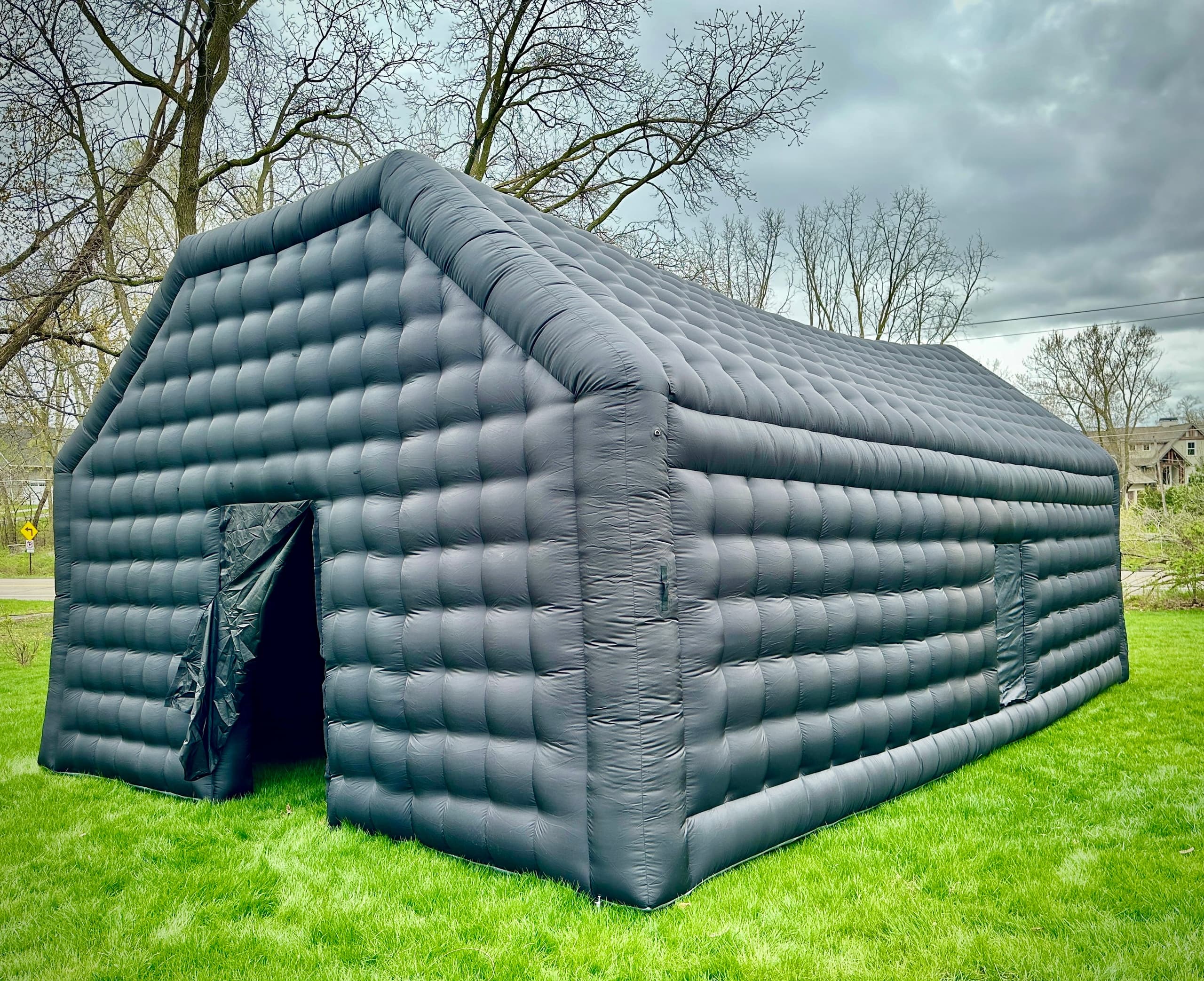 Large inflatable outdoor shelter pitched on a grassy backyard