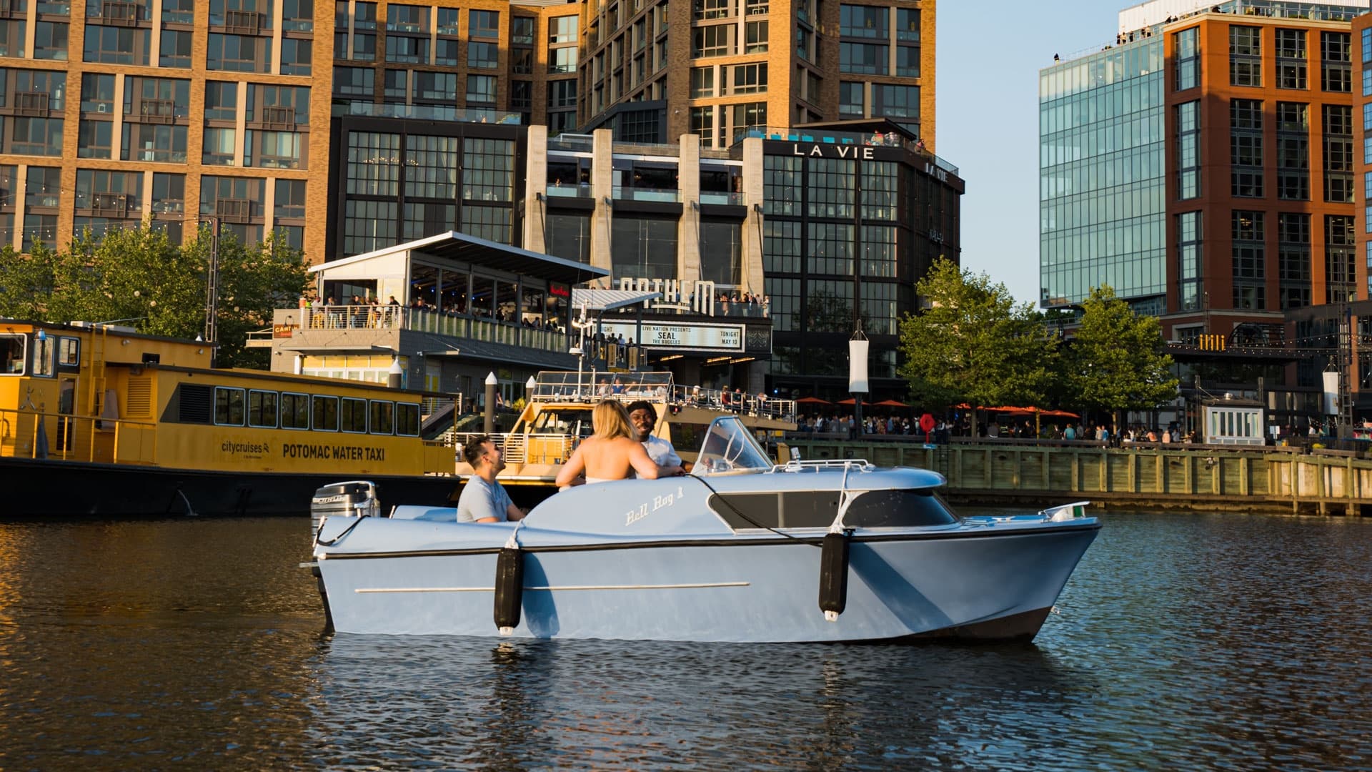 Small motorboat sightseeing along canal near waterfront buildings