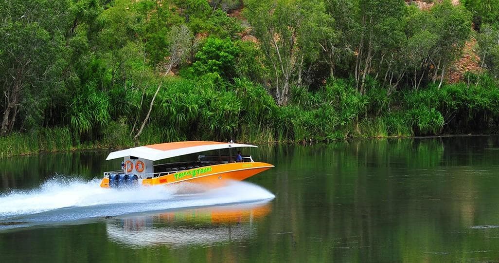 High-speed river boat skimming green jungle waterways