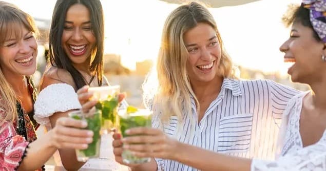 Friends enjoying cocktails on a sunny boat deck, social cruise