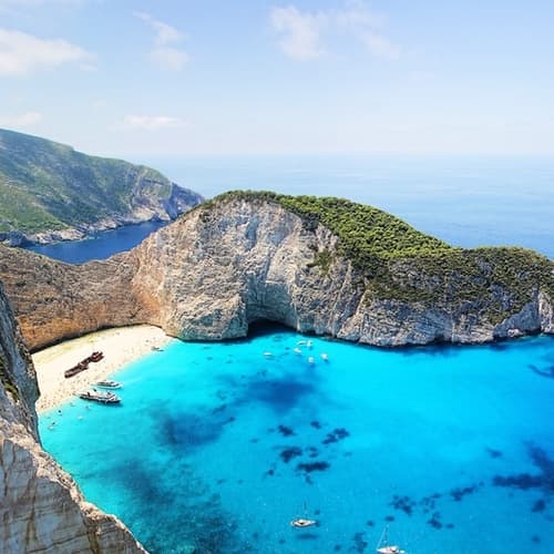 Aerial view of turquoise Zakynthos cove with anchored boats