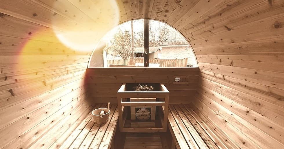Interior of barrel sauna with circular window overlooking lake