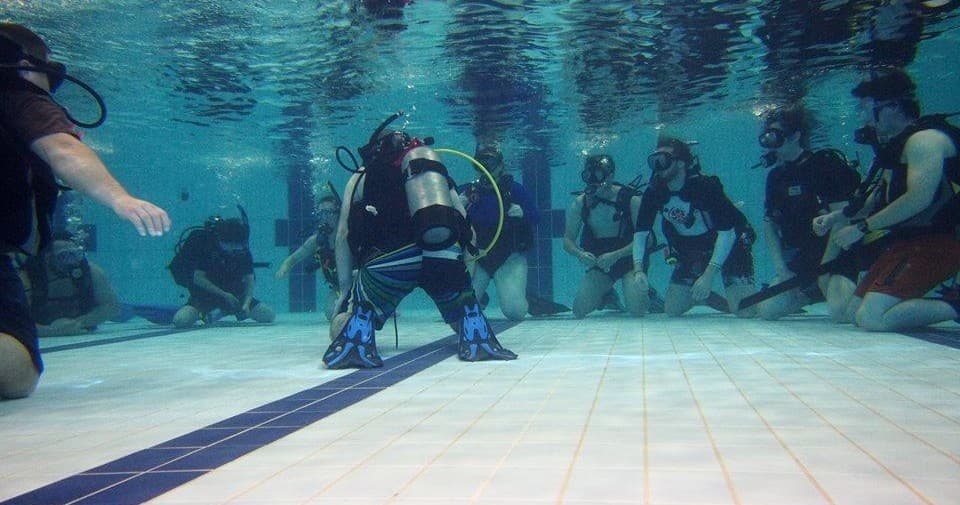 Scuba training session in pool with instructors and trainees