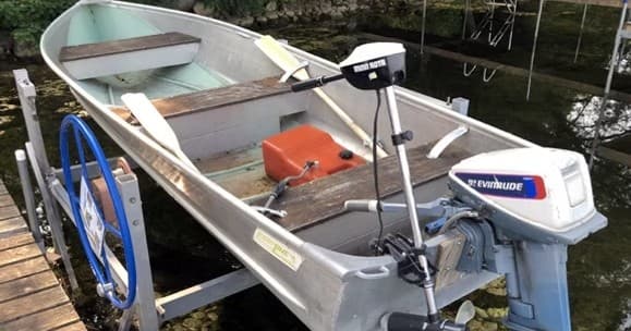 Aluminum fishing boat with outboard motor moored at dock