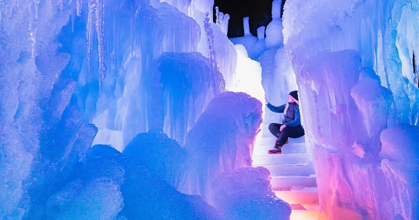 Visitor exploring illuminated ice cave at Fountain Hill winter attraction