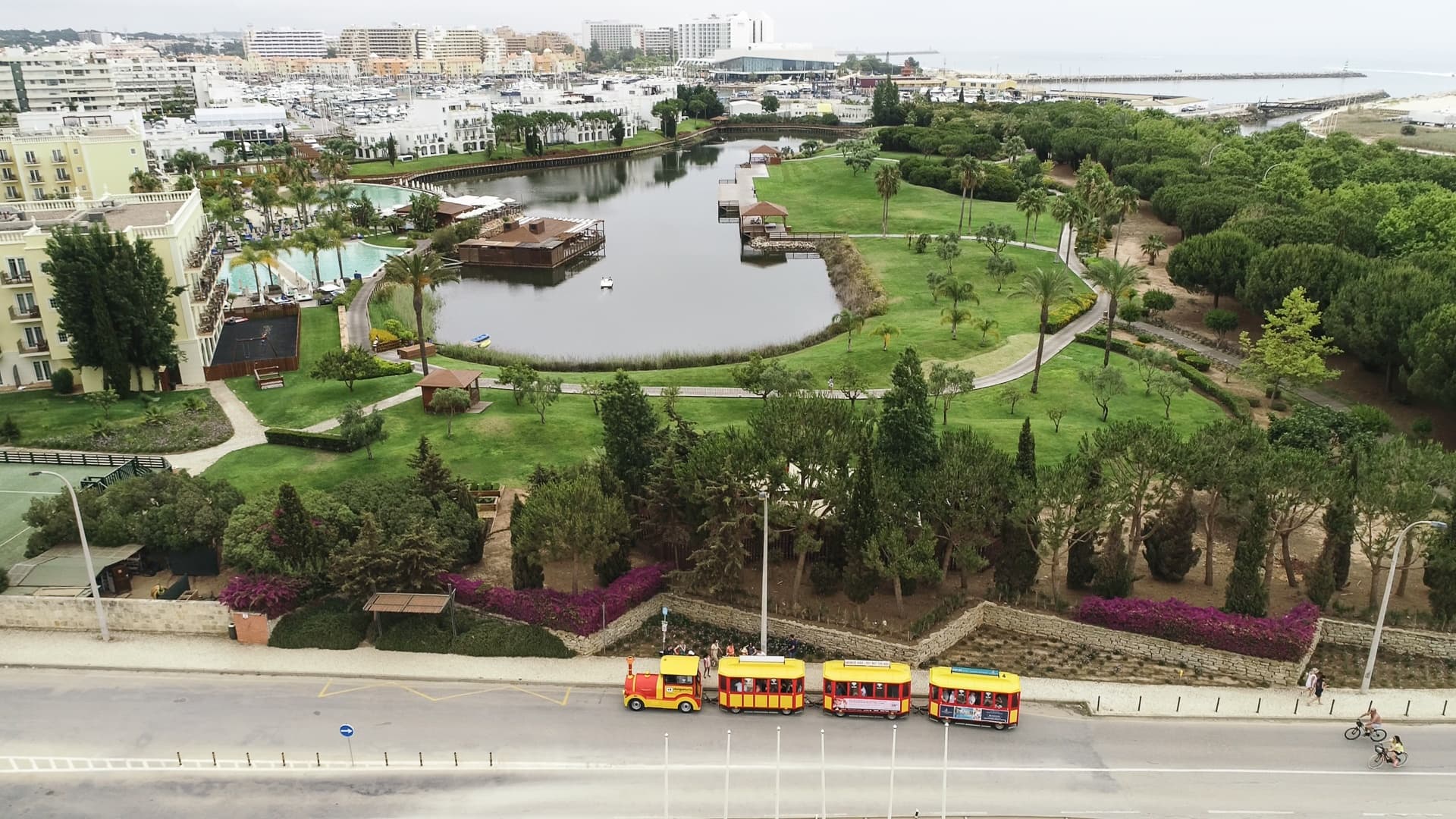 Aerial view of parklands with sightseeing train by riverfront