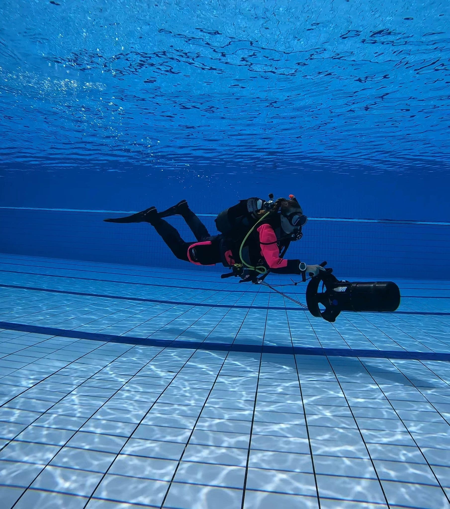 Underwater diver scooter training in pool with tiled floor