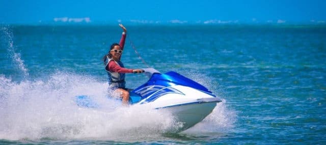 Jet ski rider skimming turquoise ocean waves near Cancun coast