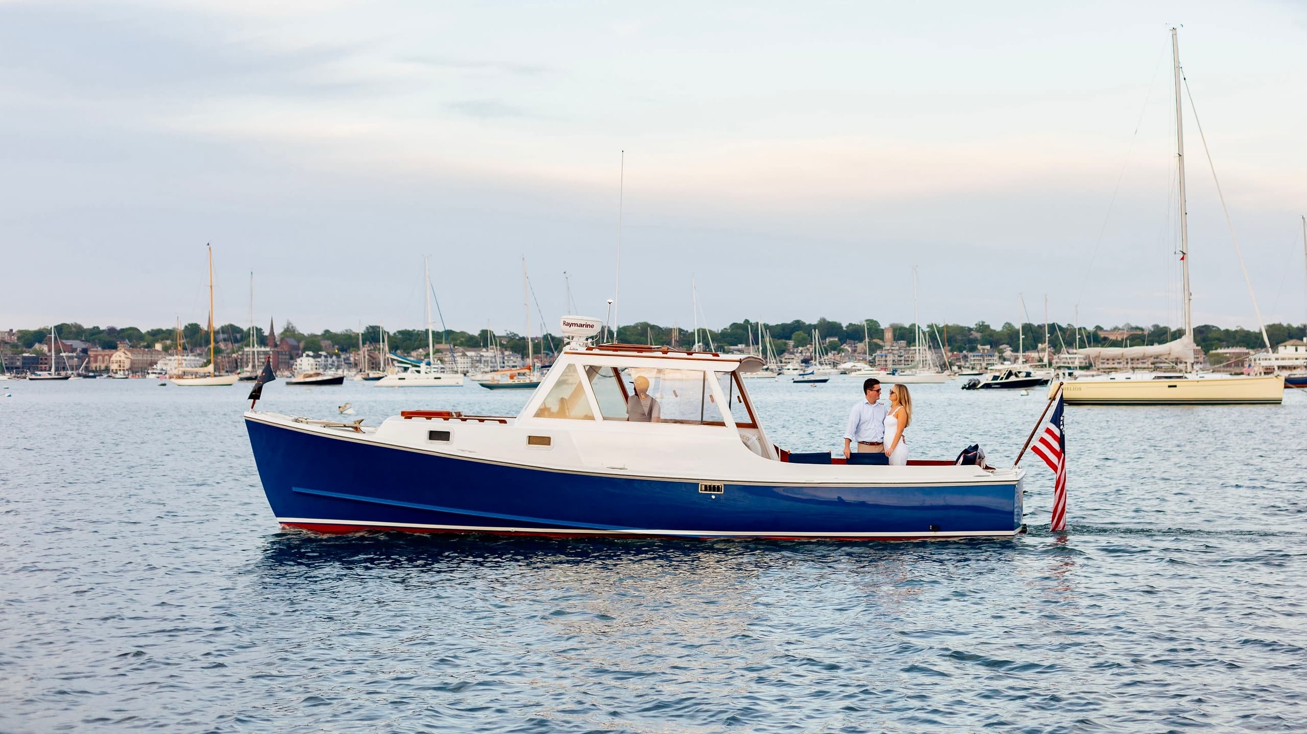 Blue charter boat cruising calm harbor waters near coastline