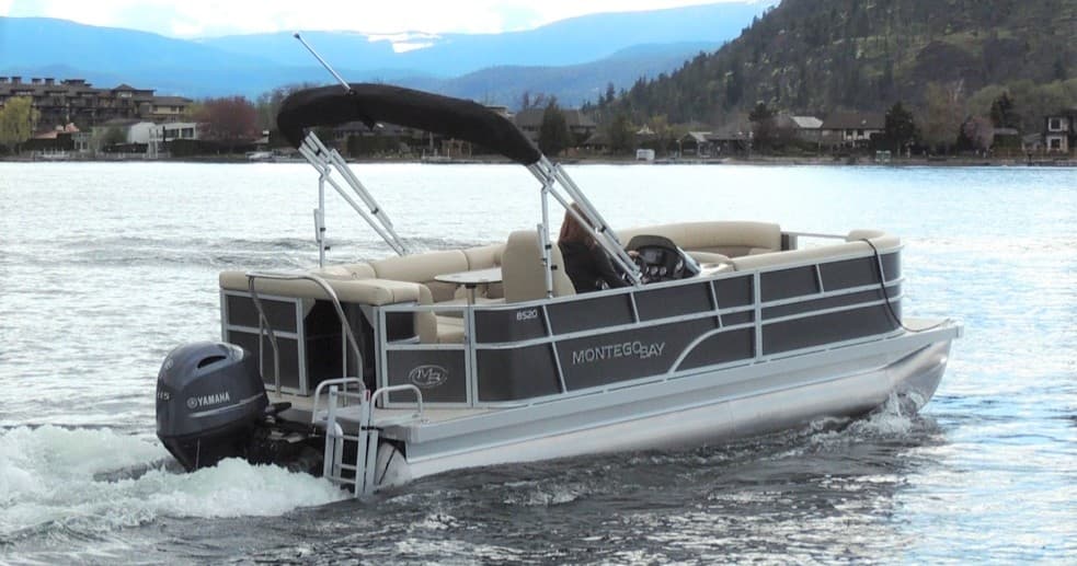 Pontoon boat cruising calm lake waters with distant hills