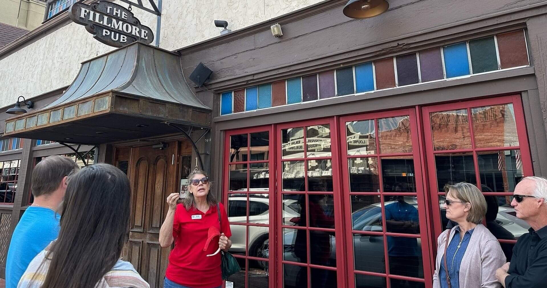 Tour guide leading food walking tour outside historic pub