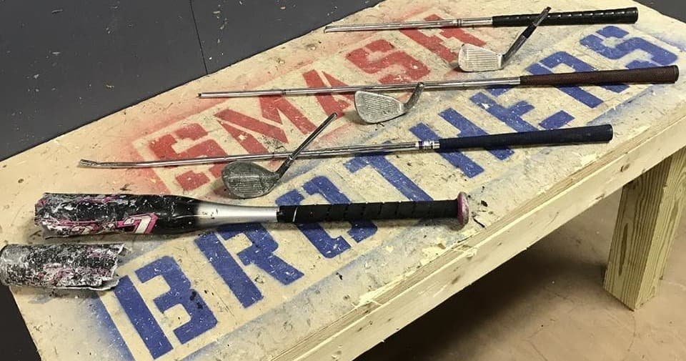 Bats and sledgehammers displayed on bench in indoor smash room