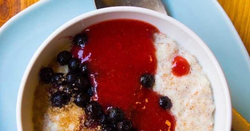 Berry porridge bowl with jam swirl in breakfast café setting