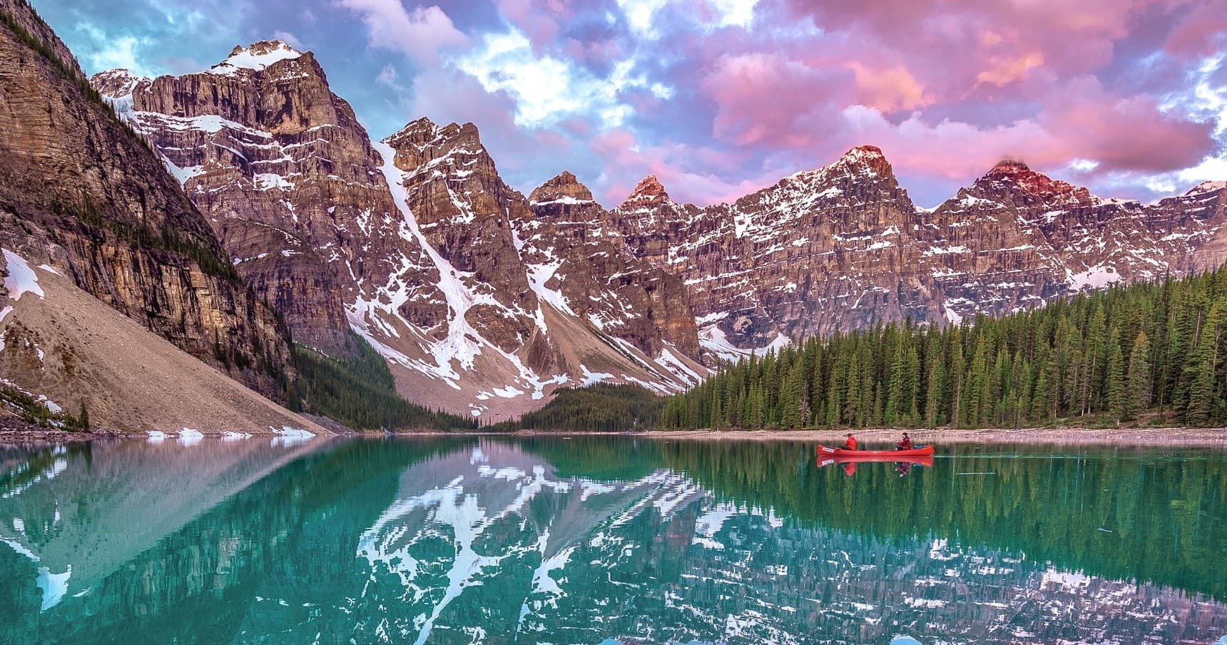 Couple embracing beside vivid turquoise alpine lake scenery