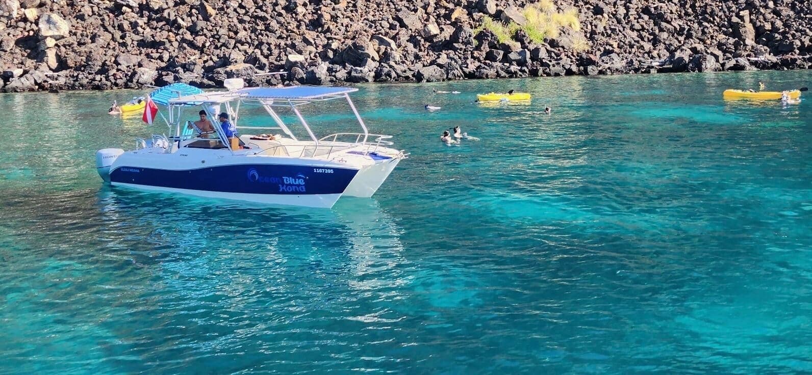 Tour boat anchored in clear turquoise bay for snorkeling