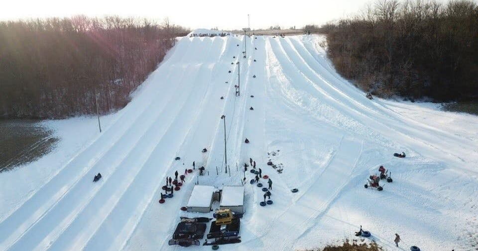 Aerial view of snow tubing park with multiple lanes and riders