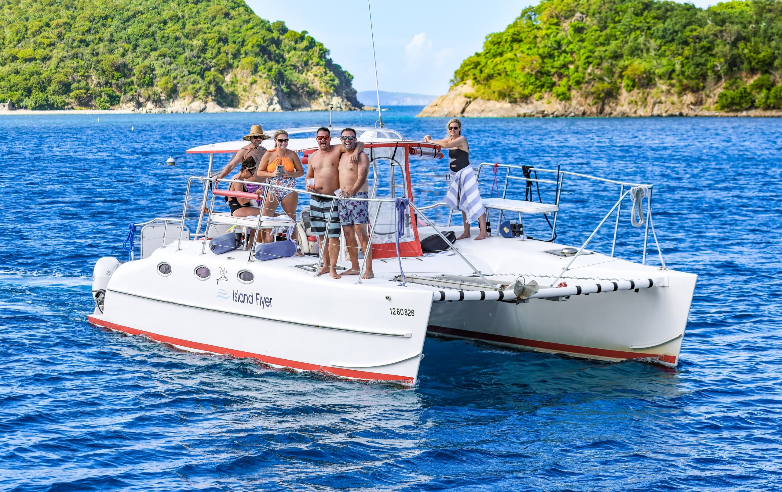 Group on catamaran deck enjoying ocean cruise near green isles
