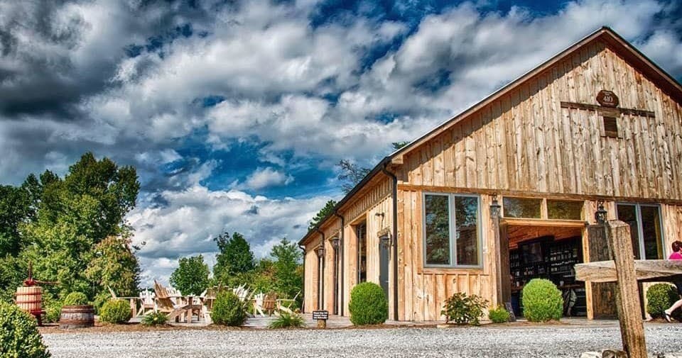 Rustic winery tasting room barn exterior under dramatic sky