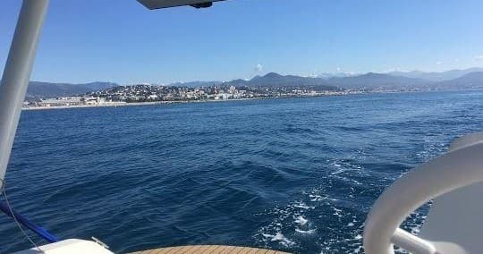 Open sea view with distant mountains from a small boat deck