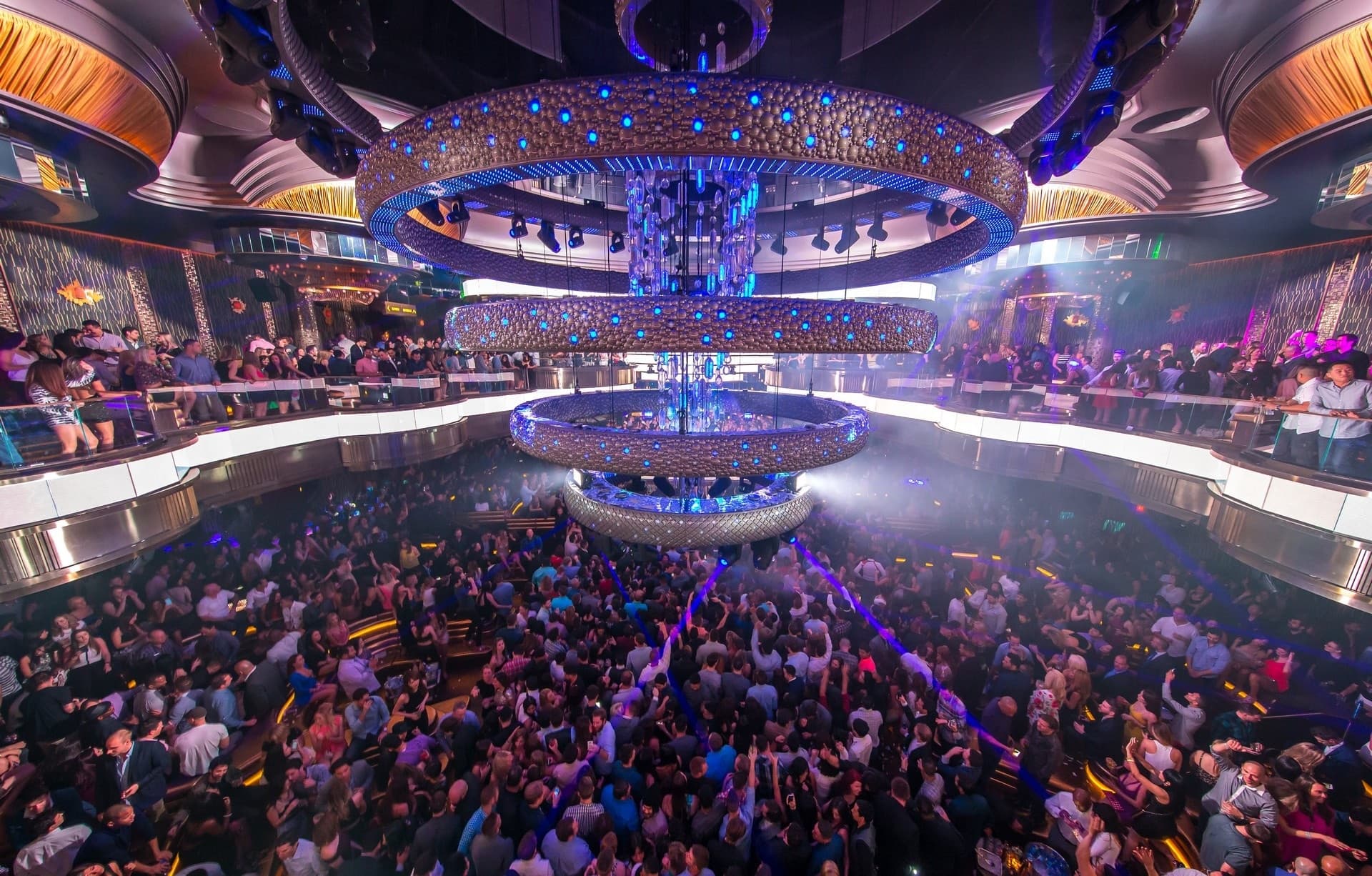 Packed nightclub concert with lights over crowded dancefloor