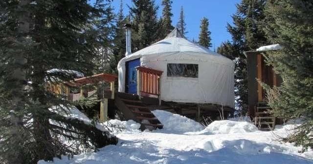 Front view yurt campsite in snowy conifer forest for backcountry stay