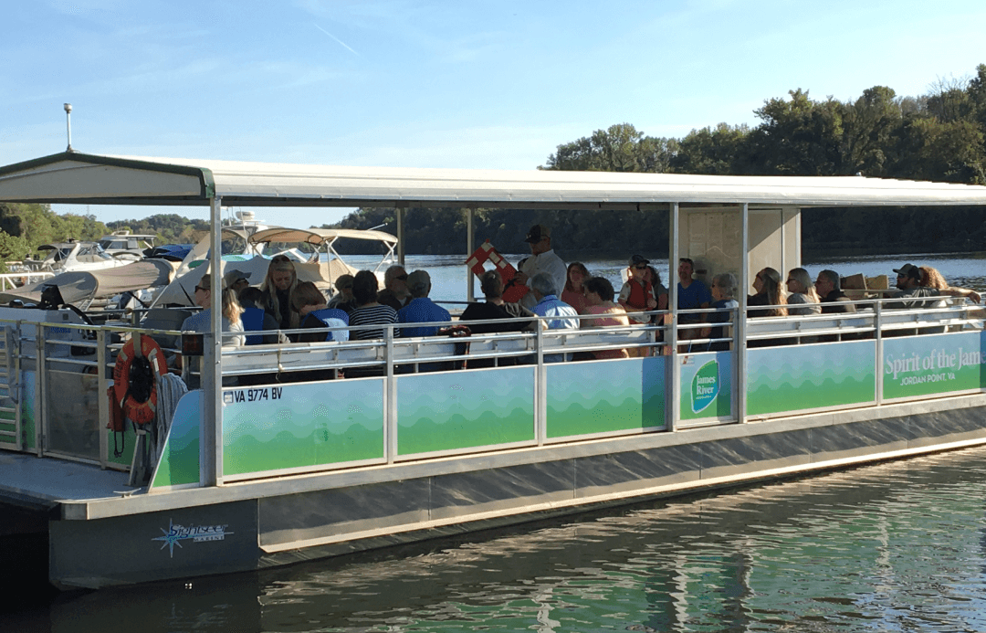 Riverboat tour cruising calm water with passengers enjoying scenery