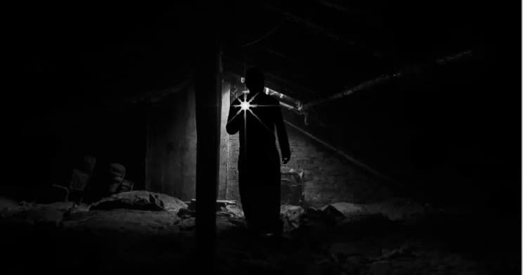 Guide holding lantern in dark historic cellar on ghost tour