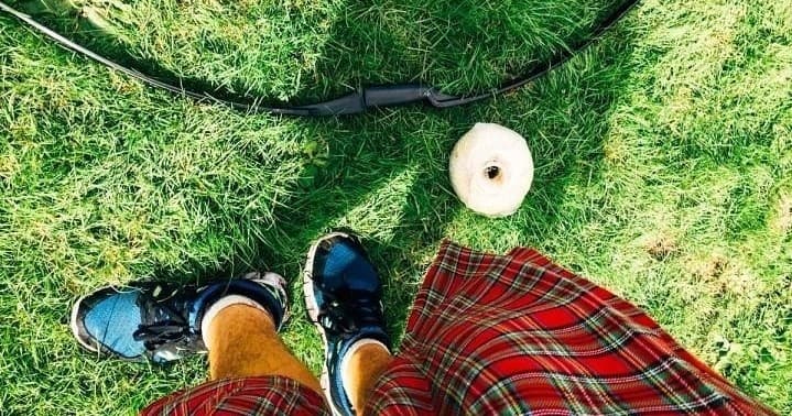 Feet on grass picnic in park with scenic lawn and outdoor gear