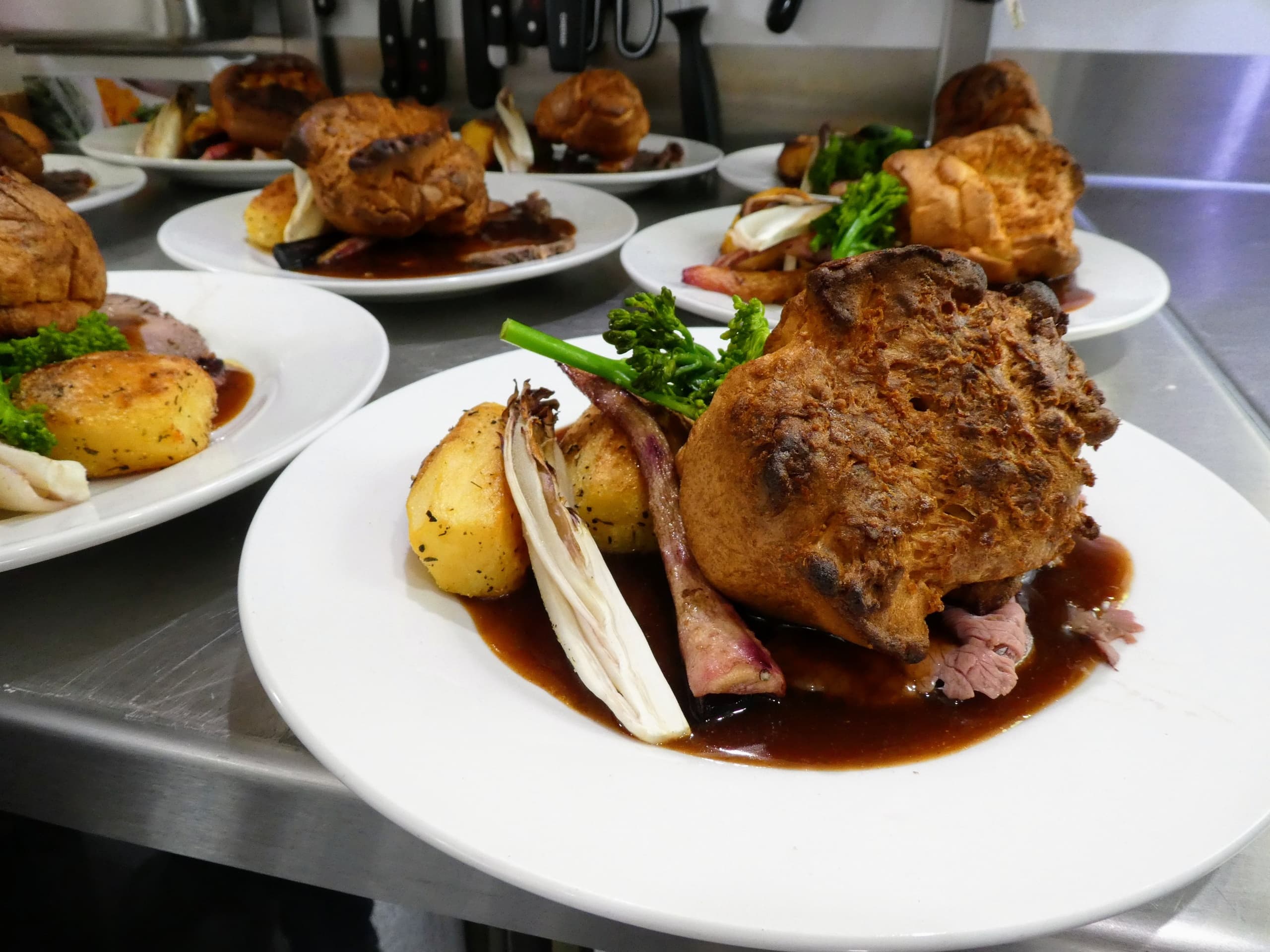 Plated roast dinners being prepared in cruise kitchen