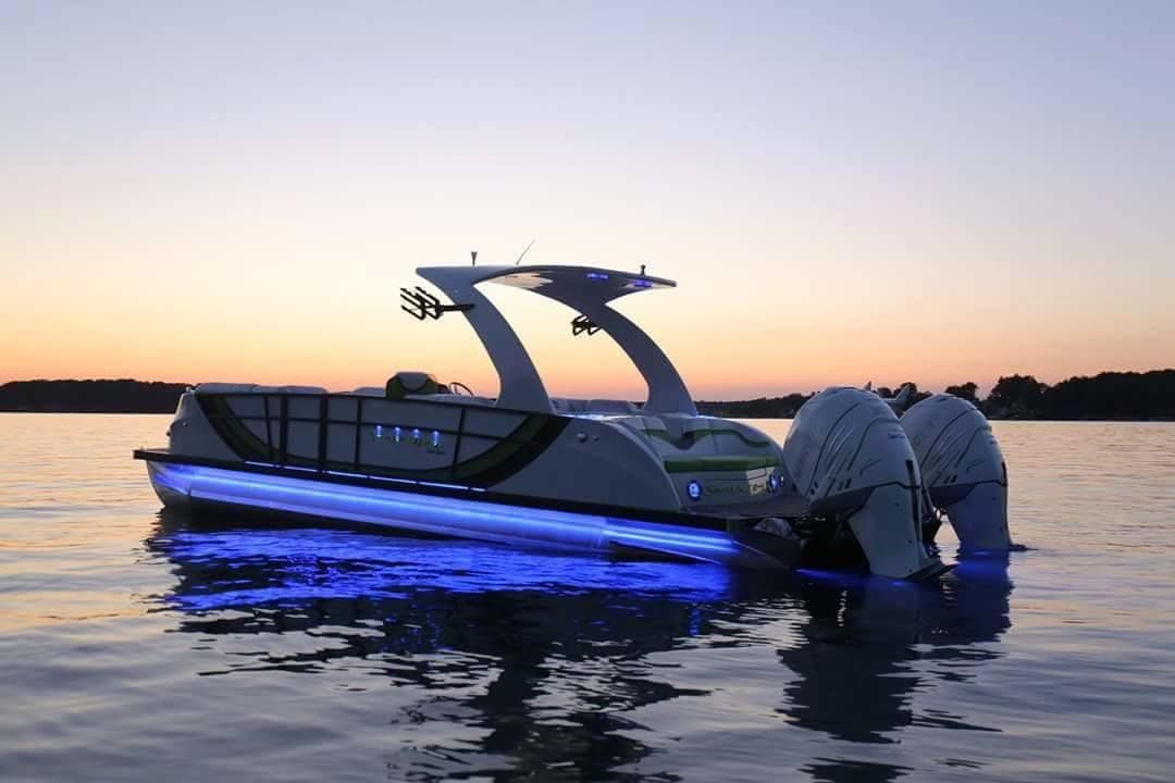 Pontoon boat at sunset with LED lights on calm lake