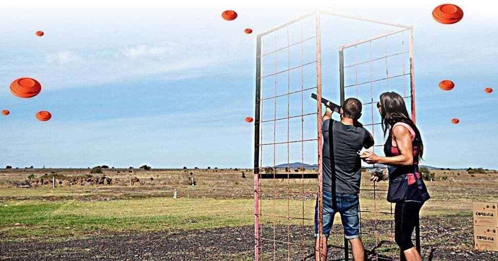 Clay target shooting on open rural range, shooters aiming