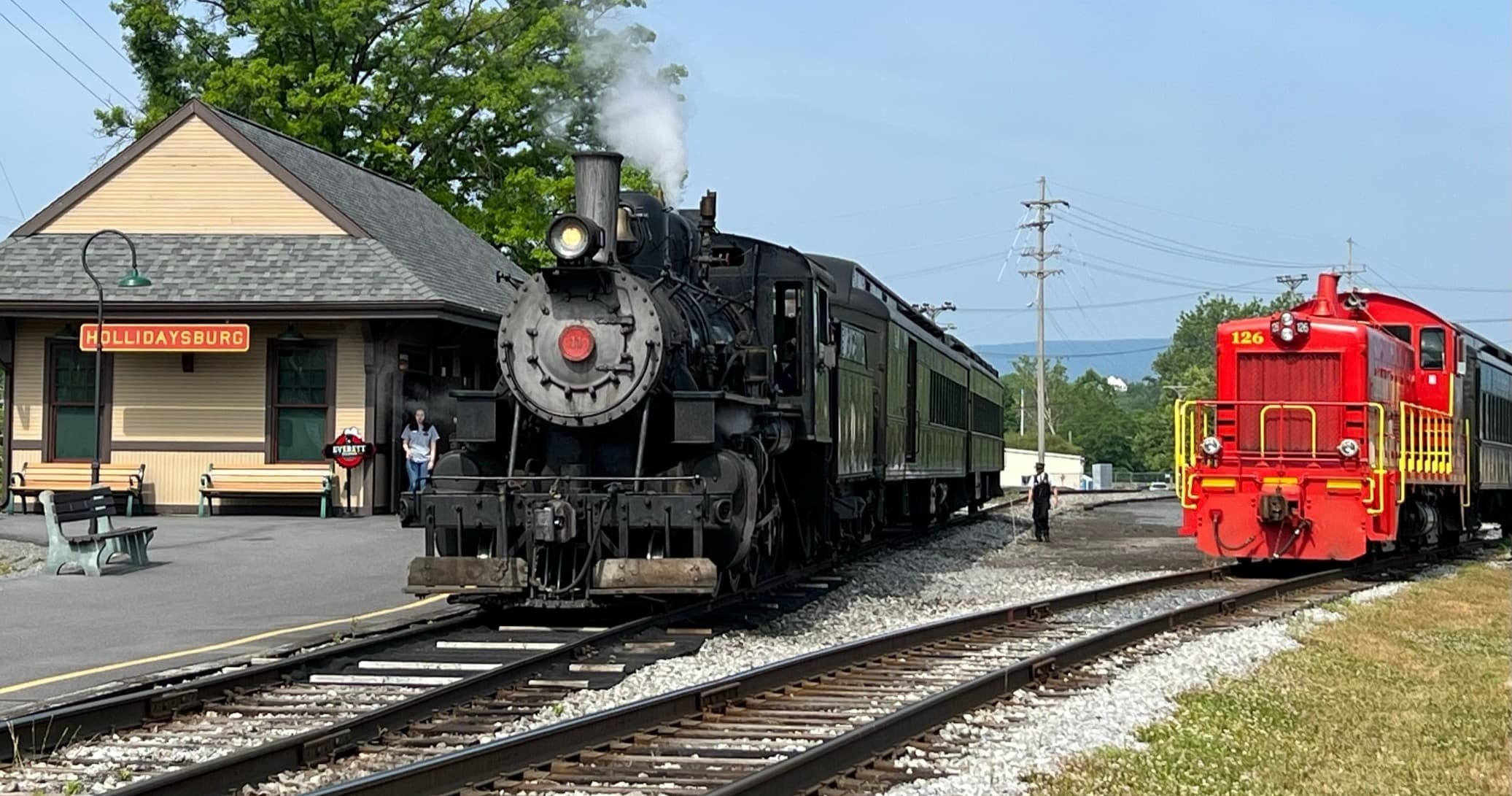 Steam locomotive at vintage depot platform, countryside excursion