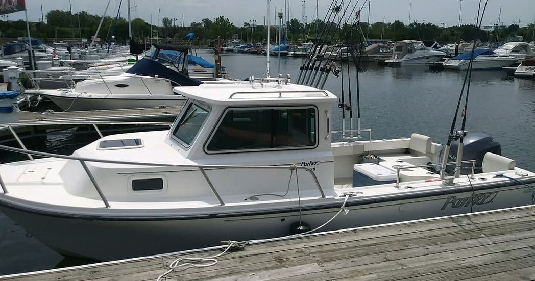 White fishing boat docked at marina, ready for offshore trip