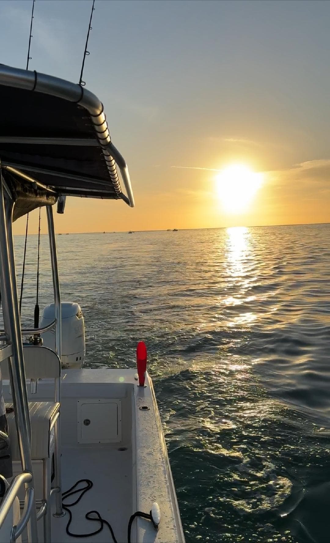Boat deck at golden sunset over calm ocean horizon
