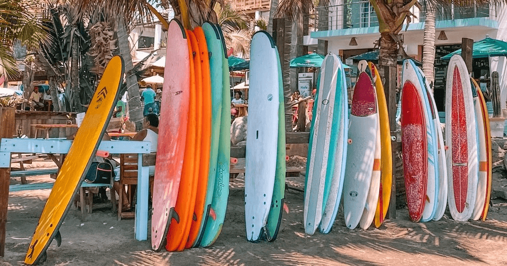 Colorful surfboards stacked on beach rack at tropical shoreline