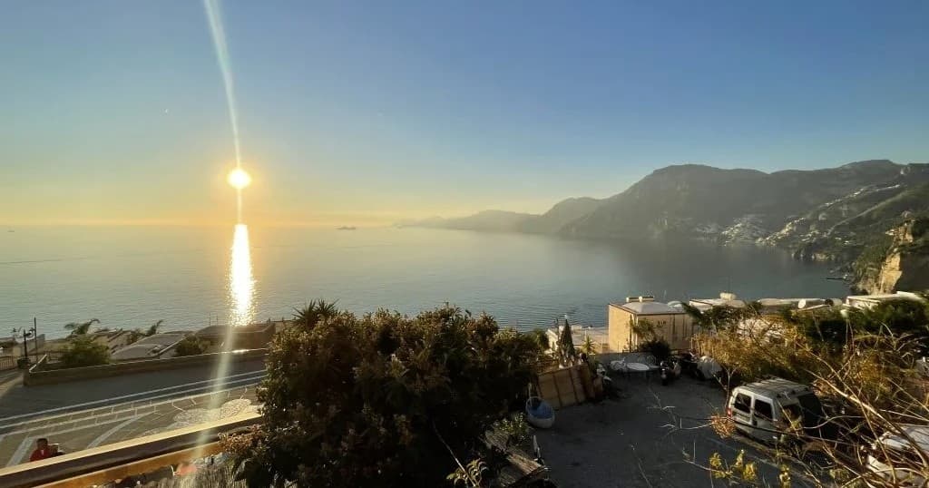 Sunset over Amalfi Coast cliffs with coastal road view