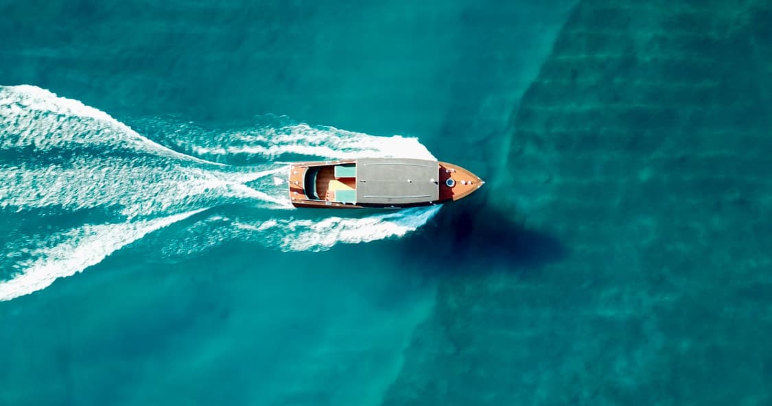 Aerial view of speedboat cutting through turquoise ocean water