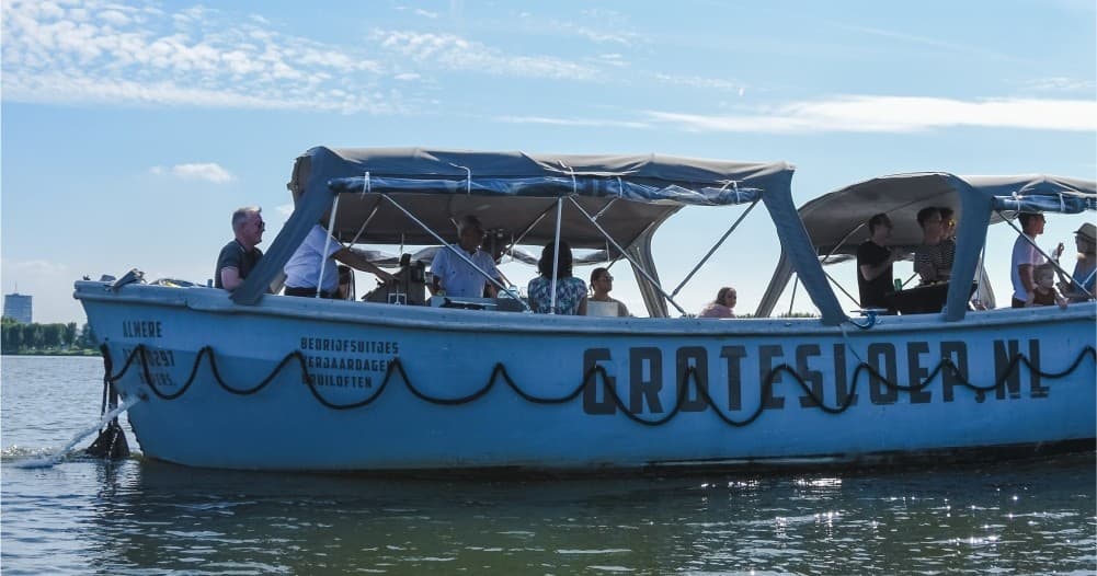 Covered tour boat with passengers cruising calm coastal waterways